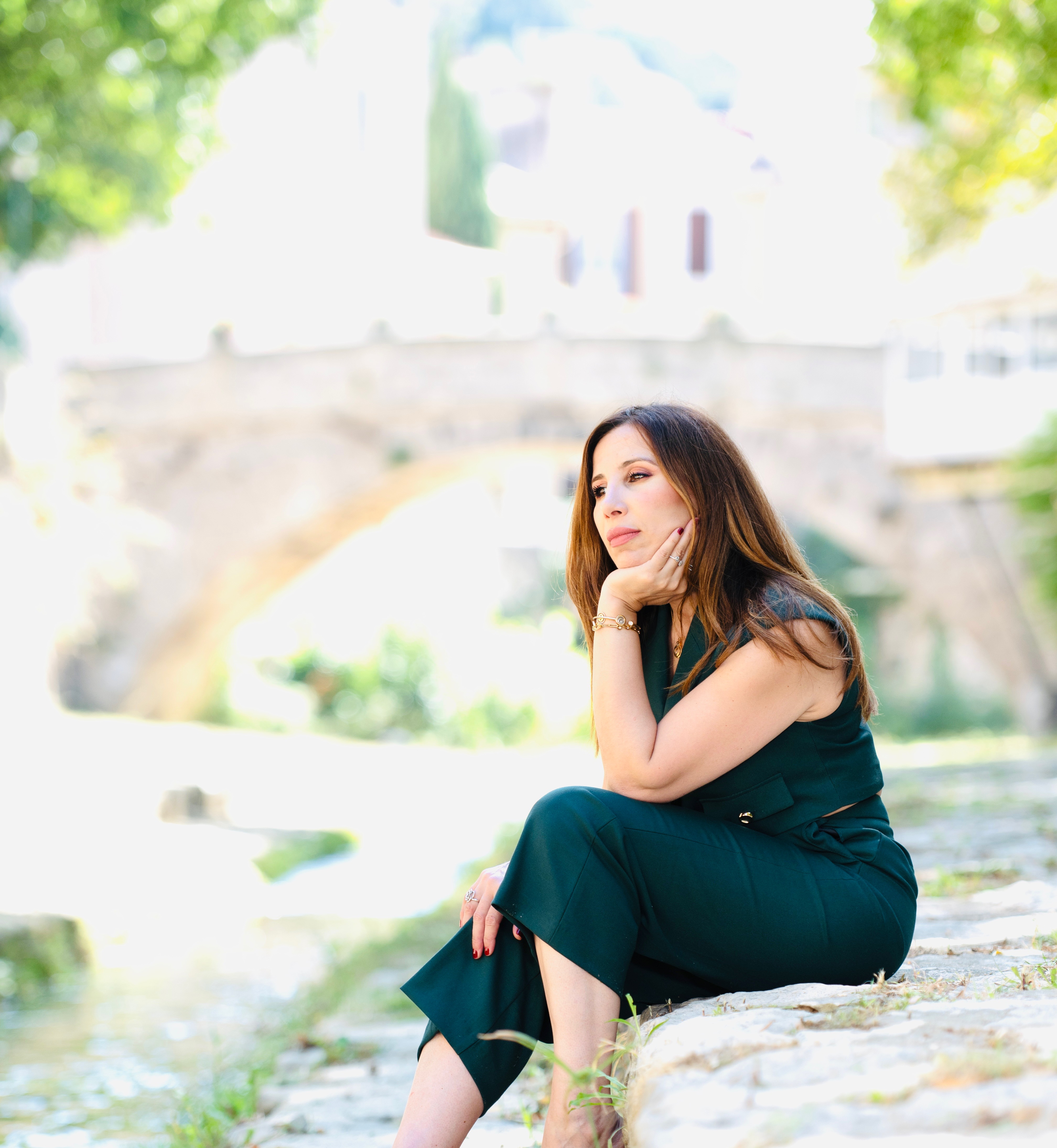 Lamia Cazalet assise au bord de l'eau, dans une lumière douce.